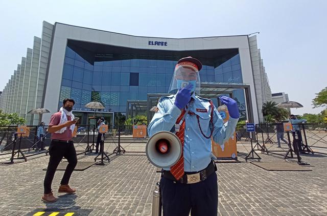 A security guard making announcements for social distancing at the Elante mall in Chandigarh on Monday. (RAVI KUMAR/HT) A security guard making announcements for social distancing at the Elante mall in Chandigarh on Monday. (RAVI KUMAR/HT)