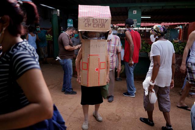Retired nurse Feridia Rojas, 82, wears cardboard shaped into a house at a market. (REUTERS) Retired nurse Feridia Rojas, 82, wears cardboard shaped into a house at a market. (REUTERS)