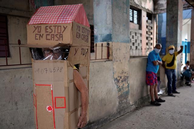 Retired nurse Feridia Rojas, 82, wears cardboard box with the note"I am at home. And you?" written on it. (REUTERS) Retired nurse Feridia Rojas, 82, wears cardboard box with the note"I am at home. And you?" written on it. (REUTERS)
