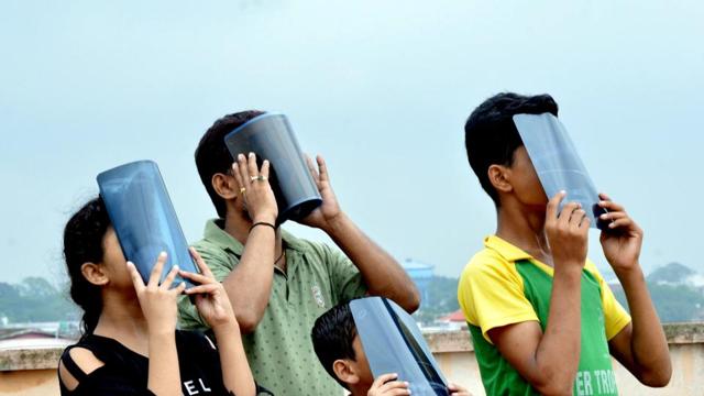 Ranchi: People view the annual solar eclipse through X-Ray films, in Ranchi. (PTI) Ranchi: People view the annual solar eclipse through X-Ray films, in Ranchi. (PTI)