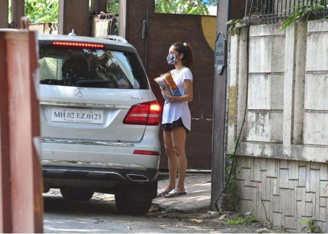 Anusha Dandekar outside her home carrying snacks delivered by Shibani and Farhan.