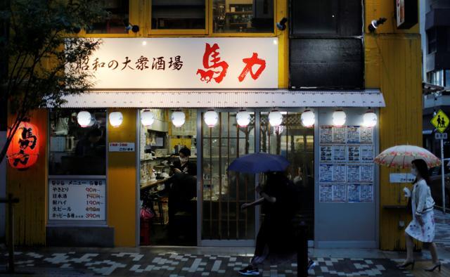 Pedestrians wearing protective masks walk past an Izakaya dining bar at a bar district which is less crowded than before amid the coronavirus disease (COVID-19) outbreak in Tokyo, Japan June 22, 2020. (REUTERS) Pedestrians wearing protective masks walk past an Izakaya dining bar at a bar district which is less crowded than before amid the coronavirus disease (COVID-19) outbreak in Tokyo, Japan June 22, 2020. (REUTERS)