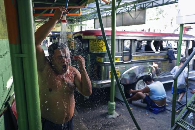 Jeepney driver Jude Recio takes a shower at the Tandang Sora terminal which have been home for them since a lockdown started three months ago, on Wednesday, June 17, 2020 in Quezon city, Philippines. (AP) Jeepney driver Jude Recio takes a shower at the Tandang Sora terminal which have been home for them since a lockdown started three months ago, on Wednesday, June 17, 2020 in Quezon city, Philippines. (AP)