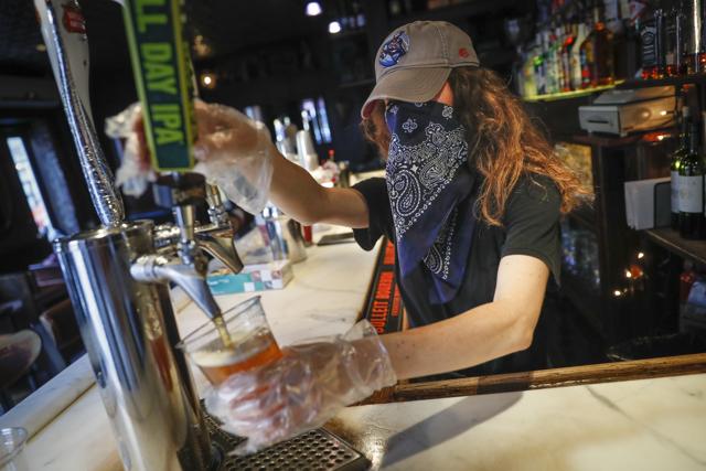 FILE - In this June 22, 2020, file photo, a bartender pours a beer for a customer at Shade Bar NYC in New York. (AP) FILE - In this June 22, 2020, file photo, a bartender pours a beer for a customer at Shade Bar NYC in New York. (AP)
