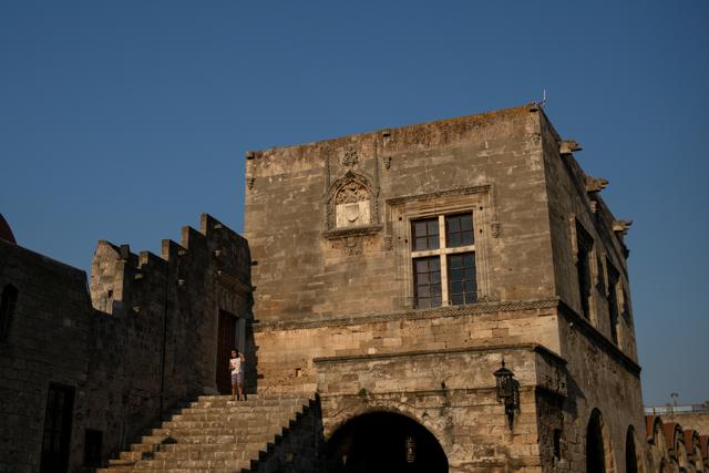 A girl stands next to a building in the Old Town of Rhodes, following the coronavirus disease (COVID-19) outbreak, on the island of Rhodes, Greece, June 30, 2020. (REUTERS)