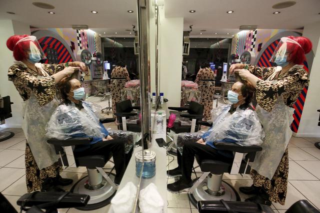 Carole Rickiby cuts the hair of customer Sandra Jacobs at Tusk Hair in Camden, London, after opening at midnight to the first post-lockdown customer as restrictions are eased across England early Saturday, July 4, 2020. (AP) Carole Rickiby cuts the hair of customer Sandra Jacobs at Tusk Hair in Camden, London, after opening at midnight to the first post-lockdown customer as restrictions are eased across England early Saturday, July 4, 2020. (AP)