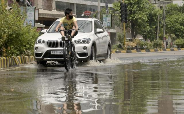 Vehicles cross a waterlogged stretch of a road in Ludhiana on Sunday. (Harsimar Pal Singh/HT) Vehicles cross a waterlogged stretch of a road in Ludhiana on Sunday. (Harsimar Pal Singh/HT)