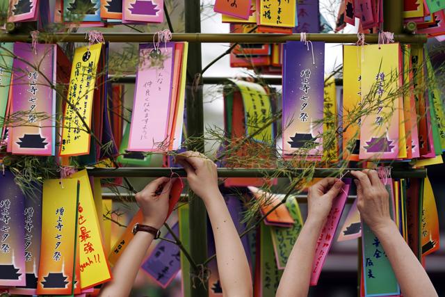 Visitors attach paper strips with their wish written on them for the Star Festival or "tanabata" to a bamboo branch at a temple in Tokyo. (AP Photo/Eugene Hoshiko) Visitors attach paper strips with their wish written on them for the Star Festival or "tanabata" to a bamboo branch at a temple in Tokyo. (AP Photo/Eugene Hoshiko)