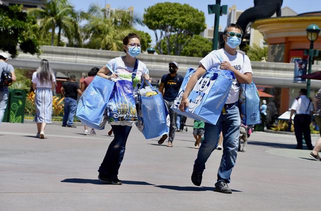 Shirley Wong, left, and her husband, Gary Lam, head toward the exit after a morning of shopping on the reopening day of the Downtown Disney District on its reopening day in Anaheim, Calif., Thursday, July 9, 2020. (AP) Shirley Wong, left, and her husband, Gary Lam, head toward the exit after a morning of shopping on the reopening day of the Downtown Disney District on its reopening day in Anaheim, Calif., Thursday, July 9, 2020. (AP)