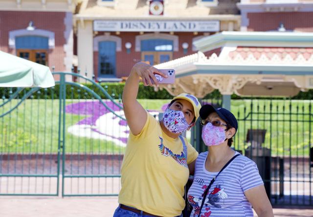 Maria Delgadillo takes a selfie with her mother Rosa Torres at the entrance to Disneyland on the reopening day of the Downtown Disney District on its reopening day in Anaheim, Calif., Thursday, July 9, 2020. (AP) Maria Delgadillo takes a selfie with her mother Rosa Torres at the entrance to Disneyland on the reopening day of the Downtown Disney District on its reopening day in Anaheim, Calif., Thursday, July 9, 2020. (AP)