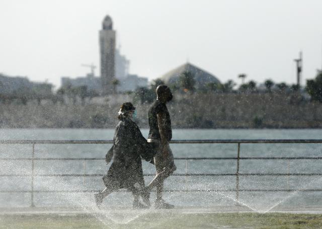Vacationers walk while wearing face masks to help prevent the spread of the coronavirus in the Red Sea beach in Jiddah, Saudi Arabia, Thursday, July 9, 2020. (AP) Vacationers walk while wearing face masks to help prevent the spread of the coronavirus in the Red Sea beach in Jiddah, Saudi Arabia, Thursday, July 9, 2020. (AP)