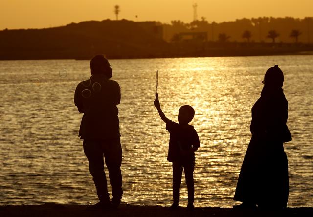 Vacationers wear face masks to help prevent the spread of the coronavirus, as a boy blows bubbles during sunset at the Red Sea beach, in Jiddah, Saudi Arabia, Thursday, July 9, 2020. (AP) Vacationers wear face masks to help prevent the spread of the coronavirus, as a boy blows bubbles during sunset at the Red Sea beach, in Jiddah, Saudi Arabia, Thursday, July 9, 2020. (AP)