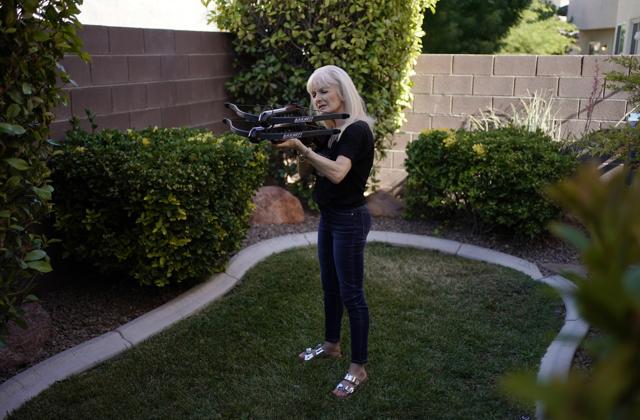 Performer Silvia Silvia practices shooting two crossbows in the backyard of her home Friday, June 19, 2020, in Las Vegas. Silvia Silvia has continued to practice at home while the show she is in, "WOW - The Vegas Spectacular" is closed due to the coronavirus. (AP) Performer Silvia Silvia practices shooting two crossbows in the backyard of her home Friday, June 19, 2020, in Las Vegas. Silvia Silvia has continued to practice at home while the show she is in, "WOW - The Vegas Spectacular" is closed due to the coronavirus. (AP)