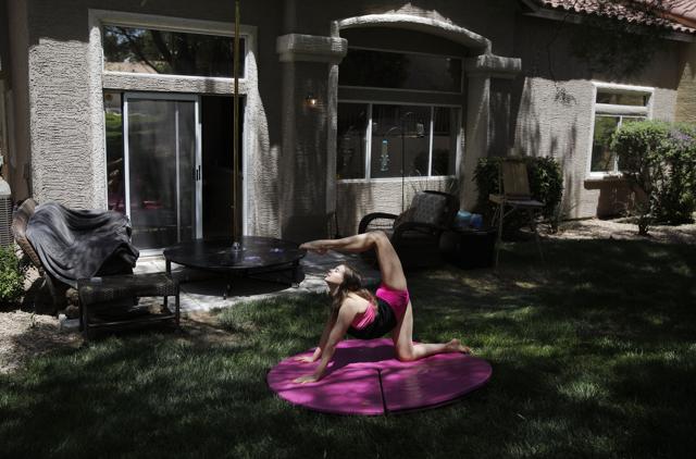Hand balancer Nataliia Istratova works out on a mat behind her apartment Saturday, June 20, 2020, in Henderson, Nev. "The most important thing is to be on stage," said Istratova who has been working out at home four or five days a week while the show she performs in, "WOW - The Vegas Spectacular" is closed due to the coronavirus. (AP) Hand balancer Nataliia Istratova works out on a mat behind her apartment Saturday, June 20, 2020, in Henderson, Nev. "The most important thing is to be on stage," said Istratova who has been working out at home four or five days a week while the show she performs in, "WOW - The Vegas Spectacular" is closed due to the coronavirus. (AP)