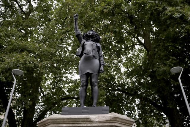 A new black resin and steel statue entitled "A Surge of Power (Jen Reid) 2020" by artist Marc Quinn stands after the statue was put up this morning on the empty plinth of the toppled statue of 17th century slave trader Edward Colston, which was pulled down during a Black Lives Matter protest in Bristol, England, Wednesday, July 15, 2020. On June 7 anti-racism demonstrators pulled the 18-foot (5.5 meter) bronze likeness of Colston down, dragged it to the nearby harbor and dumped it in the River Avon — sparking both delight and dismay in Britain and beyond. (AP) A new black resin and steel statue entitled "A Surge of Power (Jen Reid) 2020" by artist Marc Quinn stands after the statue was put up this morning on the empty plinth of the toppled statue of 17th century slave trader Edward Colston, which was pulled down during a Black Lives Matter protest in Bristol, England, Wednesday, July 15, 2020. On June 7 anti-racism demonstrators pulled the 18-foot (5.5 meter) bronze likeness of Colston down, dragged it to the nearby harbor and dumped it in the River Avon — sparking both delight and dismay in Britain and beyond. (AP)