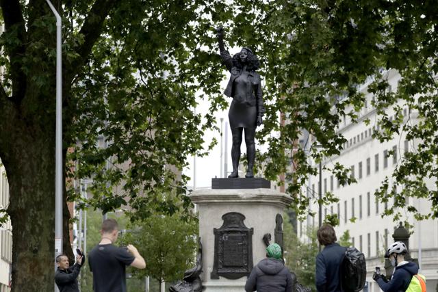 People use their phones to document a new black resin and steel statue entitled "A Surge of Power (Jen Reid) 2020" by artist Marc Quinn. (AP) People use their phones to document a new black resin and steel statue entitled "A Surge of Power (Jen Reid) 2020" by artist Marc Quinn. (AP)
