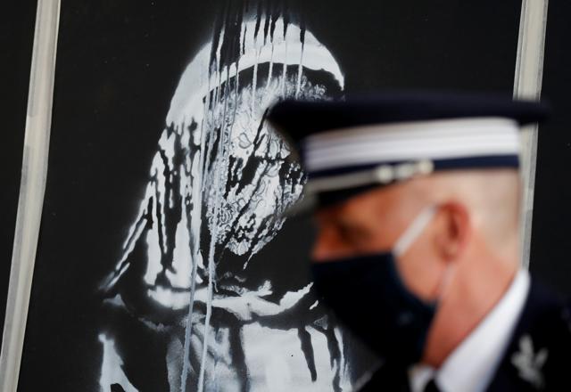 A mural by anonymous British street artist Banksy stolen from the Bataclan theatre in Paris and found in a farmhouse in central Italy is seen during the ceremony to return to France at the French embassy in Rome, Italy. July 14, 2020. (REUTERS) A mural by anonymous British street artist Banksy stolen from the Bataclan theatre in Paris and found in a farmhouse in central Italy is seen during the ceremony to return to France at the French embassy in Rome, Italy. July 14, 2020. (REUTERS)