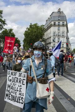 Hospital workers demonstrate during Bastille Day in Paris, Tuesday, July 14, 2020. French hospital workers are protesting to demand better pay and more investment in France's public hospital system, which is considered among the world's best but struggled to handle a flux of virus patients after years of cost cuts. Sign reads in French "the nerve of war is the stitches not just medals." (AP) Hospital workers demonstrate during Bastille Day in Paris, Tuesday, July 14, 2020. French hospital workers are protesting to demand better pay and more investment in France's public hospital system, which is considered among the world's best but struggled to handle a flux of virus patients after years of cost cuts. Sign reads in French "the nerve of war is the stitches not just medals." (AP)