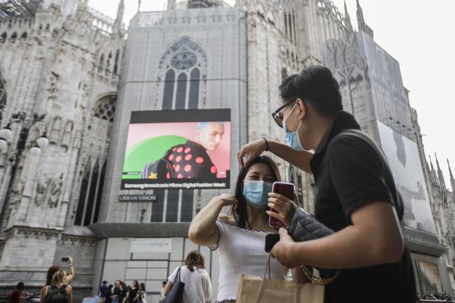 A woman takes a selfie in front of a screen on the Duomo cathedral, showing a Moschino model during the Milan Digital Fashion Week, in Milan, Italy. (AP Photo/Luca Bruno) A woman takes a selfie in front of a screen on the Duomo cathedral, showing a Moschino model during the Milan Digital Fashion Week, in Milan, Italy. (AP Photo/Luca Bruno)