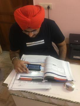 Rajveer Singh Bhatia going through his text book with the help of a magnifier. (HT Photo ) Rajveer Singh Bhatia going through his text book with the help of a magnifier. (HT Photo )