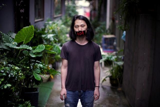 Brother Nut, Chinese performance artist with taped mouth poses for a picture in Shanghai, following the coronavirus disease (COVID-19) outbreak, China July 13, 2020. (REUTERS) Brother Nut, Chinese performance artist with taped mouth poses for a picture in Shanghai, following the coronavirus disease (COVID-19) outbreak, China July 13, 2020. (REUTERS)