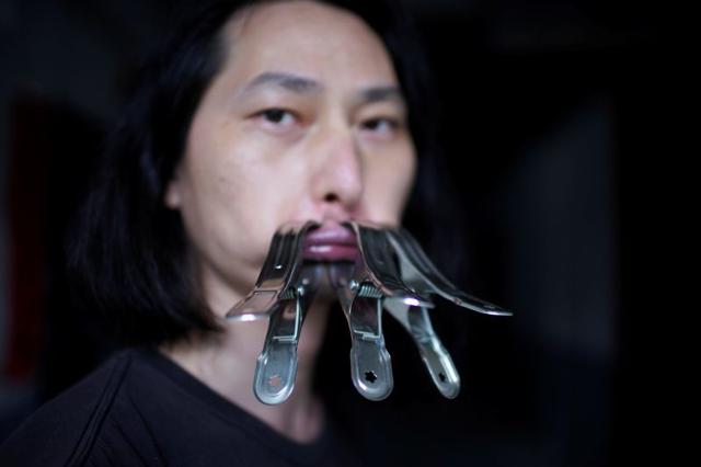 Brother Nut, Chinese performance artist with three metallic clips sealing his mouth, poses for a picture in Shanghai, following the coronavirus disease (COVID-19) outbreak, China July 13, 2020. (REUTERS) Brother Nut, Chinese performance artist with three metallic clips sealing his mouth, poses for a picture in Shanghai, following the coronavirus disease (COVID-19) outbreak, China July 13, 2020. (REUTERS)