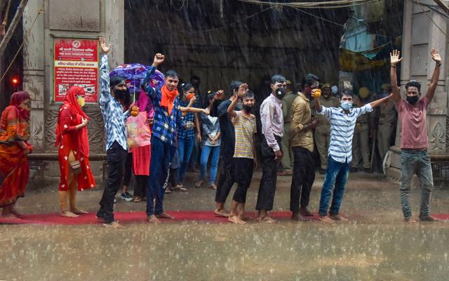 Varanasi: Devotees wait amid rains to perform 'abhishek' of Lord Shiva at the Kashi Vishwanath temple on the occasion of the third 'Somwar' of the holy month of 'Shravan', in Varanasi, Monday, July 20, 2020. (PTI) Varanasi: Devotees wait amid rains to perform 'abhishek' of Lord Shiva at the Kashi Vishwanath temple on the occasion of the third 'Somwar' of the holy month of 'Shravan', in Varanasi, Monday, July 20, 2020. (PTI)