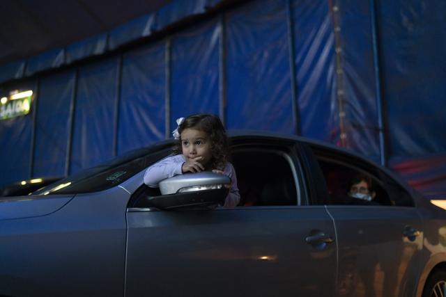 A child watches from inside the car artists performing at the Estoril Circus in a drive-in format amid the new coronavirus pandemic in Itaguai greater Rio de Janeiro, Brazil, Saturday, July 18, 2020. (AP) A child watches from inside the car artists performing at the Estoril Circus in a drive-in format amid the new coronavirus pandemic in Itaguai greater Rio de Janeiro, Brazil, Saturday, July 18, 2020. (AP)