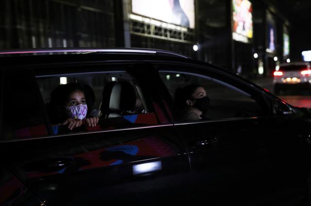 Nina Siqueira, 7, looks at an art piece next to her mother Joana from inside their family car as they visit a drive-through art exhibition, during the global outbreak of the coronavirus disease (COVID-19), in Sao Paulo, Brazil July 17, 2020. (REUTERS)