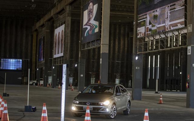 People take in an art exhibit from their car as they drive through a warehouse displaying paintings and photos in Sao Paulo, Brazil, Friday, July 24, 2020, amid the new coronavirus pandemic. (AP)