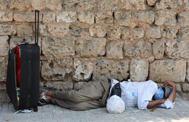 A man lies on the ground as he wears a face mask to prevent the spread of the coronavirus disease (COVID-19) in Beirut, Lebanon July 28, 2020. (REUTERS) A man lies on the ground as he wears a face mask to prevent the spread of the coronavirus disease (COVID-19) in Beirut, Lebanon July 28, 2020. (REUTERS)