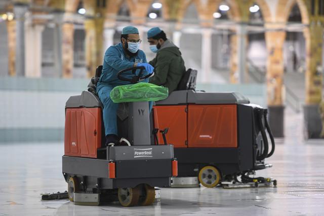 In this photo released by the Saudi Media Ministry, workers polish the white marble floors surrounding Islam’s holiest site, the Kaaba, inside the Grand Mosque in Mecca, Saudi Arabia, July 29, 2020, ahead of the arrival of as little as 1,000 pilgrims for this year’s downsized hajj pilgrimage. This year’s much smaller pilgrimage is taking place amid a global coronavirus pandemic. (AP) In this photo released by the Saudi Media Ministry, workers polish the white marble floors surrounding Islam’s holiest site, the Kaaba, inside the Grand Mosque in Mecca, Saudi Arabia, July 29, 2020, ahead of the arrival of as little as 1,000 pilgrims for this year’s downsized hajj pilgrimage. This year’s much smaller pilgrimage is taking place amid a global coronavirus pandemic. (AP)