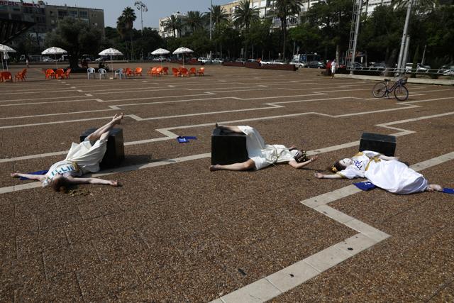 Performers, part of an artwork by Israeli artist Itay Zalait, lie on the ground near an installation that includes a sculpture of Israeli Prime Minister Benjamin Netanyahu sitting at a table recalling the famous "Last Supper", amid a wave of almost daily protests against Netanyahu's alleged corruption and his government's handling of the coronavirus disease (COVID-19) crisis, at Rabin Square in Tel Aviv, Israel July 29, 2020. (REUTERS) Performers, part of an artwork by Israeli artist Itay Zalait, lie on the ground near an installation that includes a sculpture of Israeli Prime Minister Benjamin Netanyahu sitting at a table recalling the famous "Last Supper", amid a wave of almost daily protests against Netanyahu's alleged corruption and his government's handling of the coronavirus disease (COVID-19) crisis, at Rabin Square in Tel Aviv, Israel July 29, 2020. (REUTERS)