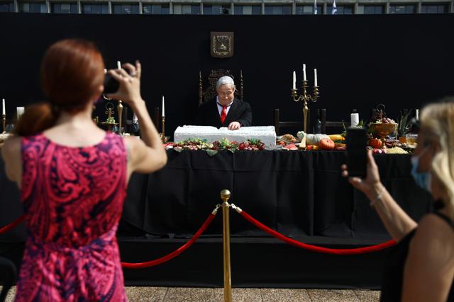 People use their phones to document an artwork by Israeli artist Itay Zalait, that includes a sculpture of Israeli Prime Minister Benjamin Netanyahu sitting at a table recalling the famous "Last Supper", amid a wave of almost daily protests against Netanyahu's alleged corruption and his government's handling of the coronavirus disease (COVID-19) crisis, displayed at Rabin Square in Tel Aviv, Israel July 29, 2020. REUTERS/Ammar Awad (REUTERS) People use their phones to document an artwork by Israeli artist Itay Zalait, that includes a sculpture of Israeli Prime Minister Benjamin Netanyahu sitting at a table recalling the famous "Last Supper", amid a wave of almost daily protests against Netanyahu's alleged corruption and his government's handling of the coronavirus disease (COVID-19) crisis, displayed at Rabin Square in Tel Aviv, Israel July 29, 2020. REUTERS/Ammar Awad (REUTERS)