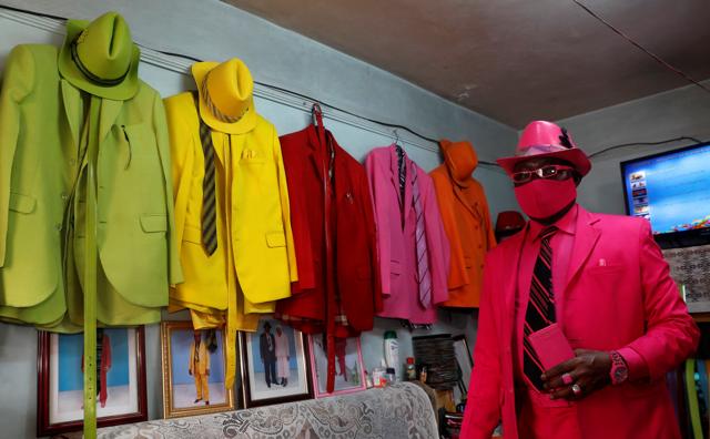 James Maina Mwangi poses for a photograph as he displays his attire comprising at least 160 suits with matching accessories including a mask to prevent the coronavirus disease (COVID-19) infection at his residence in Nairobi, Kenya July 30, 2020. (REUTERS) James Maina Mwangi poses for a photograph as he displays his attire comprising at least 160 suits with matching accessories including a mask to prevent the coronavirus disease (COVID-19) infection at his residence in Nairobi, Kenya July 30, 2020. (REUTERS)