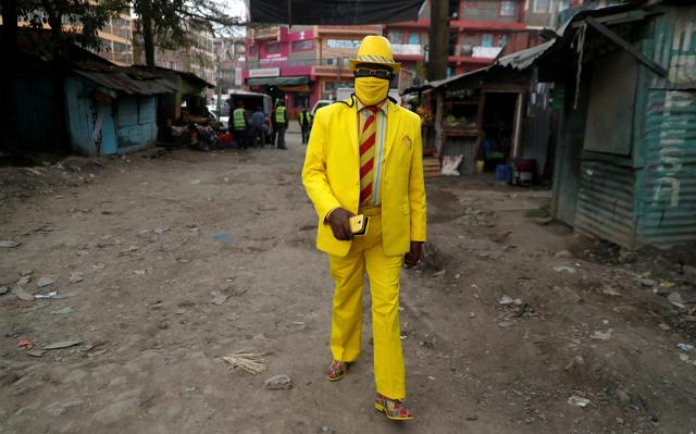 Kenyan fashionista James Maina Mwangi walks along a street as he displays his attire comprising at least 160 suits with matching accessories including a mask to prevent the coronavirus disease (COVID-19) infection, near his residence in Nairobi, Kenya July 30, 2020. (REUTERS) Kenyan fashionista James Maina Mwangi walks along a street as he displays his attire comprising at least 160 suits with matching accessories including a mask to prevent the coronavirus disease (COVID-19) infection, near his residence in Nairobi, Kenya July 30, 2020. (REUTERS)