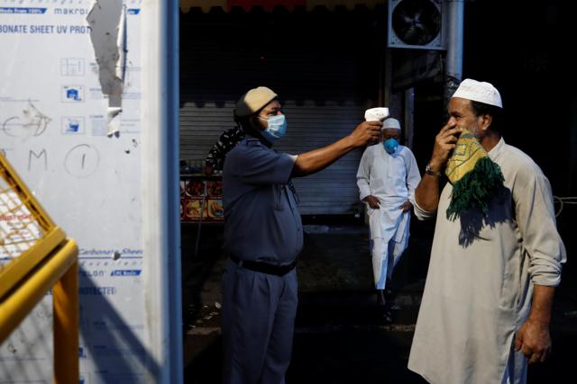 A policeman takes the temperature of a Muslim man arriving to offer Eid al-Adha prayers at the Jama Masjid (Grand Mosque) during the outbreak of the coronavirus disease (COVID-19), in the old quarters of Delhi, India, August 1, 2020. (REUTERS) A policeman takes the temperature of a Muslim man arriving to offer Eid al-Adha prayers at the Jama Masjid (Grand Mosque) during the outbreak of the coronavirus disease (COVID-19), in the old quarters of Delhi, India, August 1, 2020. (REUTERS)