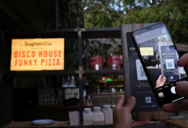 A client using his mobile phone scans the QR code to place an order of a pizza with its ingredientes through of the "Funky Pay" app, where the app replaces waiters at Funky Pizza restaurant in Palafrugell, near Girona, Costa Brava, Spain July 31, 2020. (REUTERS) A client using his mobile phone scans the QR code to place an order of a pizza with its ingredientes through of the "Funky Pay" app, where the app replaces waiters at Funky Pizza restaurant in Palafrugell, near Girona, Costa Brava, Spain July 31, 2020. (REUTERS)