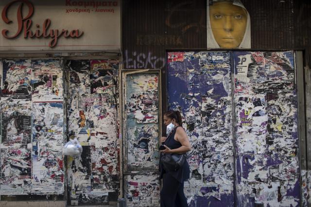 A woman with a face mask walks past shuttered stores in Athens, on Tuesday, Aug. 4, 2020. Greek authorities introduced tougher restrictions the last days following an increase in infections. (AP) A woman with a face mask walks past shuttered stores in Athens, on Tuesday, Aug. 4, 2020. Greek authorities introduced tougher restrictions the last days following an increase in infections. (AP)
