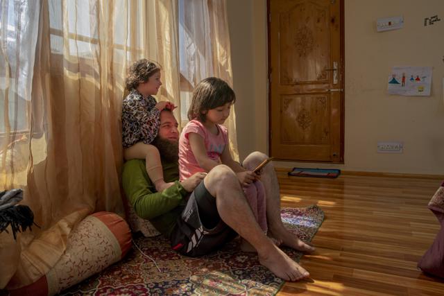 Khalid Bazaz plays with his niece Sundas Irfan, as his daughter Maria Khalid sits on his lap and watches online classes, at their home in Srinagar, Indian controlled Kashmir, Thursday, July 23, 2020. Confined to their homes, students have found it challenging to study online with the painstakingly slow internet connections, which also faces outages following the frequent gunbattles between rebels and Indian soldiers. With no high-speed internet, many educators are unable to upload video lectures and conduct online classes. But some are making the best of limited resources. "I have to spend 3 hours every day with Maria as she is too young to handle zoom meetings and like every child she is not interested in these online classes," Khalid said. (AP) Khalid Bazaz plays with his niece Sundas Irfan, as his daughter Maria Khalid sits on his lap and watches online classes, at their home in Srinagar, Indian controlled Kashmir, Thursday, July 23, 2020. Confined to their homes, students have found it challenging to study online with the painstakingly slow internet connections, which also faces outages following the frequent gunbattles between rebels and Indian soldiers. With no high-speed internet, many educators are unable to upload video lectures and conduct online classes. But some are making the best of limited resources. "I have to spend 3 hours every day with Maria as she is too young to handle zoom meetings and like every child she is not interested in these online classes," Khalid said. (AP)