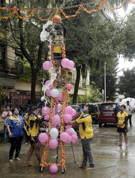 Devotees use a ladder and maintain social distancing while celebrating Dahi Handi festival in Mumbai on Wednesday. (ANI)