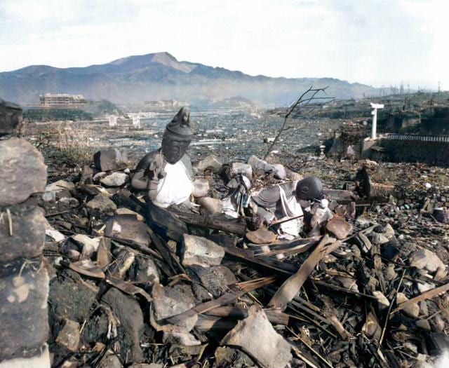 In this black and white AP photo digitally colorized and published in 2020 by Anju Niwata and Hidenori Watanave, a battered religious figure stands witness on a hill above a burn-razed valley at Nagasaki, on Sept. 24, 1945, after the second atomic bomb ever used in warfare was dropped by the U.S. over the Japanese industrial center. 