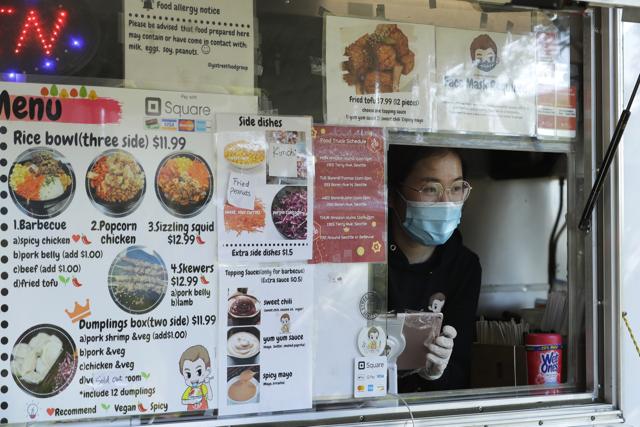 Yuli Schen takes an order as she works in her YS Street Food food truck, Monday, Aug. 10, 2020, near the suburb of Lynnwood, Wash., north of Seattle. (AP)