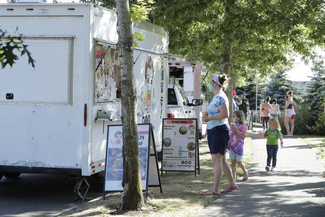 Customers line up to order from the YS Street Food food truck, Monday, Aug. 10, 2020, near the suburb of Lynnwood, Wash., north of Seattle. Long seen as a feature of city living, food trucks are now finding customers in the suburbs during the coronavirus pandemic as people are working and spending most of their time at home. (AP)