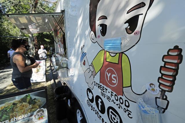 A customer orders from the YS Street Food food truck, Monday, Aug. 10, 2020, near the suburb of Lynnwood, Wash., north of Seattle. (AP)