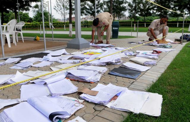 Cops spreading out records to dry them after water receded at the Baltana police post. Weapons and ammunition had been moved to safety as well. (Keshav Singh/HT)