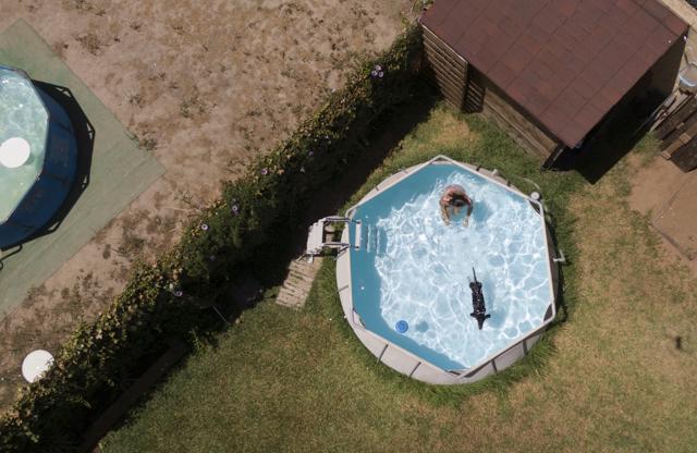 Luisa swims with her dog Oscar in a plastic pool in Seville, Spain on Aug. 16, 2020. They have had the pool for several years. On hot days she swims with her dogs. (AP) Luisa swims with her dog Oscar in a plastic pool in Seville, Spain on Aug. 16, 2020. They have had the pool for several years. On hot days she swims with her dogs. (AP)