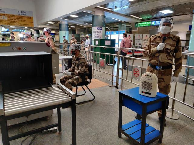 Security personnel wearing masks, gloves and face shields at a metro station. (Soumya Pillai/HT Photo )