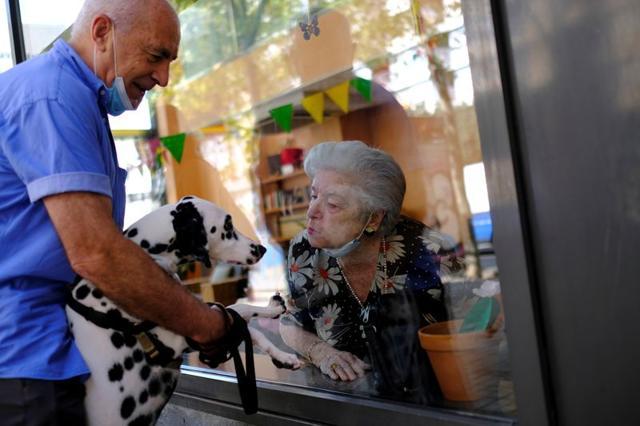 An elderly woman blows a kiss a dog. (REUTERS) An elderly woman blows a kiss a dog. (REUTERS)