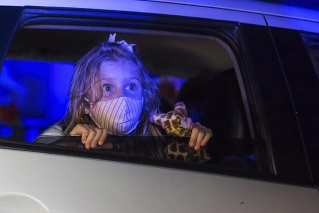 A child, wearing a protective face mask, watches a performance from inside a car, at the Hopi Hari horror theme amusement park. (AP) A child, wearing a protective face mask, watches a performance from inside a car, at the Hopi Hari horror theme amusement park. (AP)